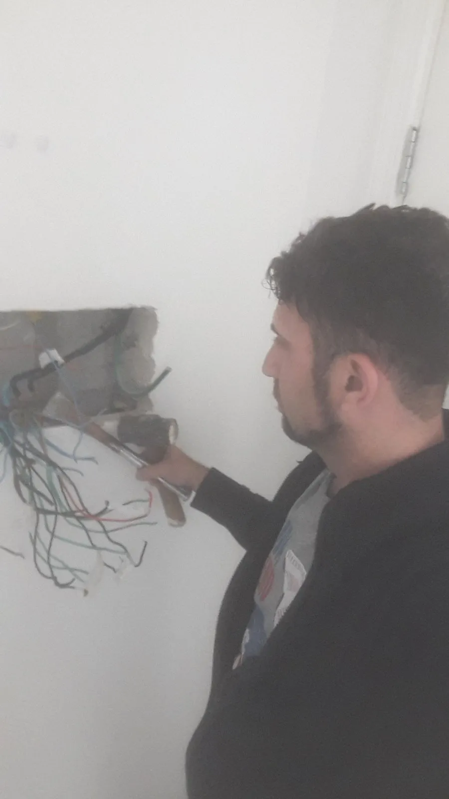 Engenheiro Márcio Zottino trabalhando na fiação de uma parede