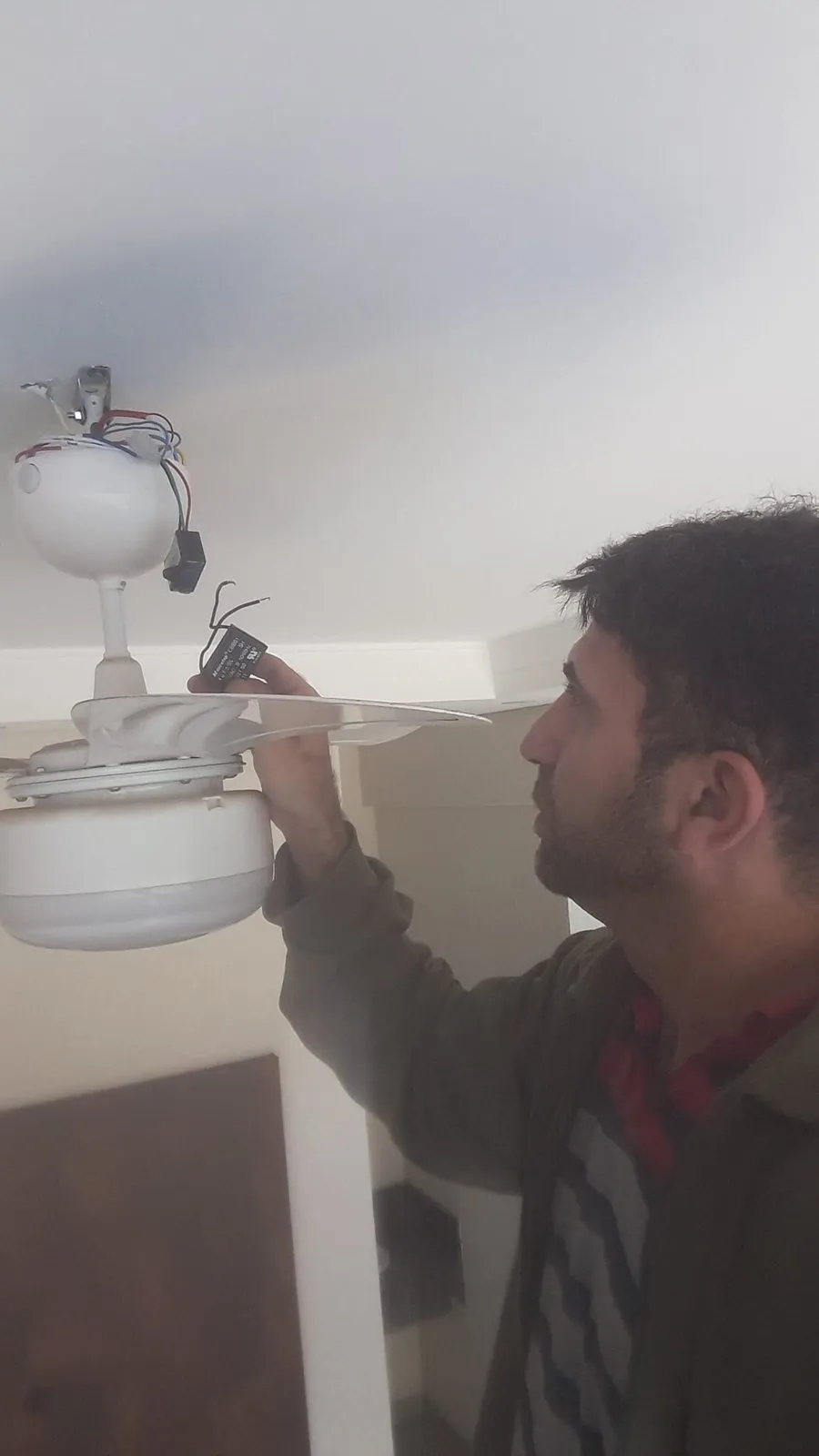 Engenheiro Márcio Zottino instalando um ventilador de teto