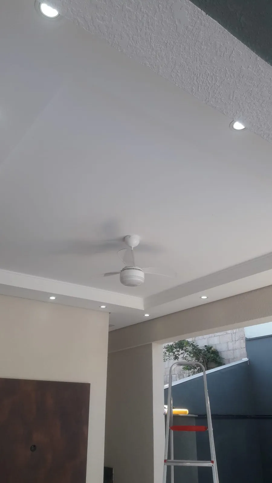 Ventilador de teto e spots de LED instalados em sala